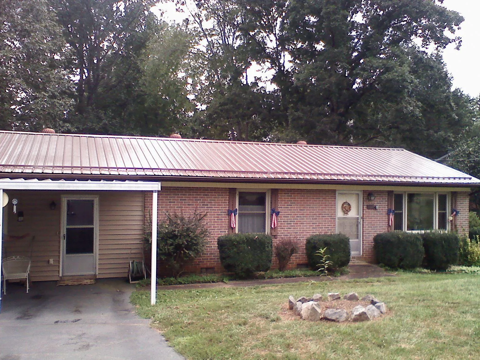 Bronze metal roof and carport on a brick ranch home — Roof Repair work by our crew in Brewster